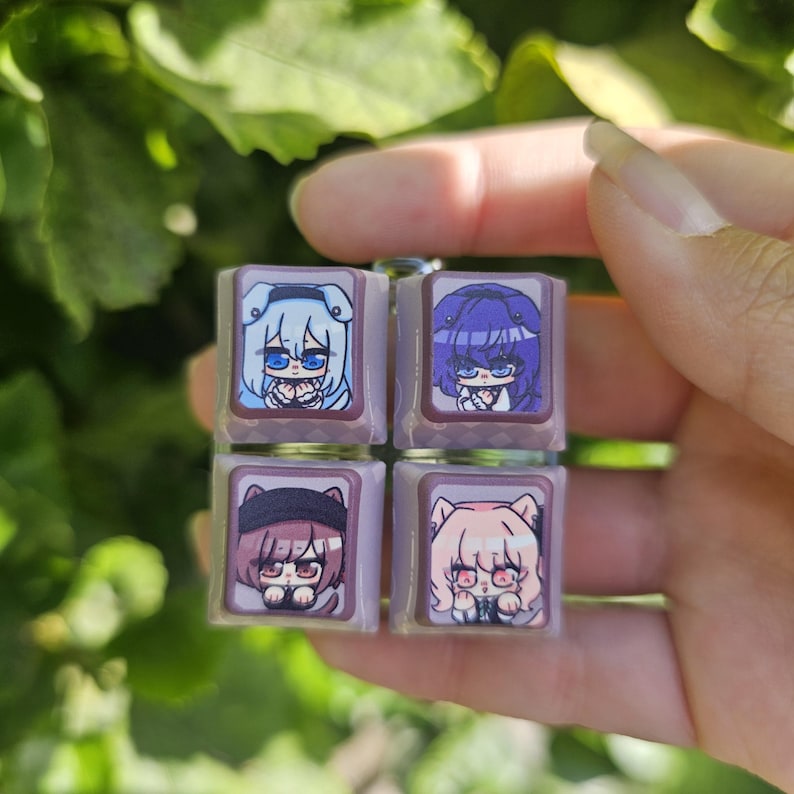 K&ouml;nnte beinhalten: Vier quadratische Tastenkappen mit verschiedenen Anime-Charakteren darauf gedruckt. Die Tastenkappen sind lila, braun und wei&szlig; mit einem hellbraunen Hintergrund. Die Charaktere sind ein M&auml;dchen mit blauen Haaren, ein M&auml;dchen mit lila Haaren, ein M&auml;dchen mit braunen Haaren und ein M&auml;dchen mit rosa Haaren.