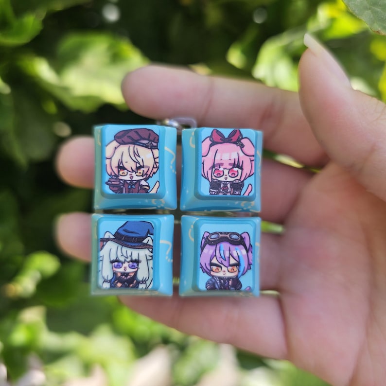 K&ouml;nnte beinhalten: Vier blaue und wei&szlig;e Tastenkappen mit verschiedenen Anime-Charakteren. Die Tastenkappen sind in einem 2x2-Raster angeordnet. Die Charaktere tragen alle verschiedene Outfits und haben verschiedene Frisuren. Die Tastenkappen sind aus Kunststoff und haben eine gl&auml;nzende Oberfl&auml;che.