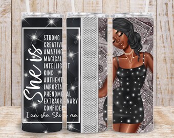 May include: A black and silver tumbler with a black background and white glitter accents. The tumbler features a black and white illustration of a woman in a black dress with a sparkling design. The text "She is" is written vertically in white with a sparkling design. The text "Strong, Creative, Amazing, Magical, Intelligent, Kind, Authentic, Important, Phenomenal, Extraordinary, Confident" is written in white with a sparkling design. The text "I am she. She is me." is written in white with a sparkling design.