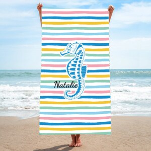 Puede incluir: Una toalla de playa colorida con un dise&ntilde;o de caballito de mar azul y el nombre "Natalie" impreso en ella.