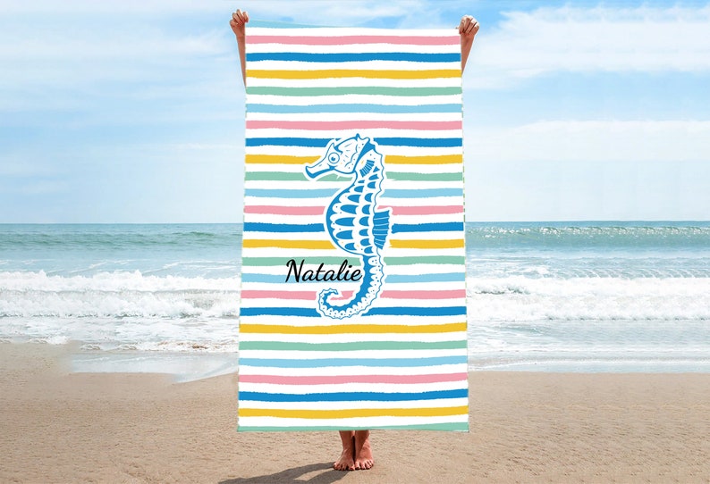 Puede incluir: Una toalla de playa colorida con un dise&ntilde;o de caballito de mar azul y el nombre "Natalie" impreso en ella.