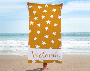 Puede incluir: Una toalla de playa amarilla con un patrón de estrellas blancas y el nombre "Victoria" impreso en la parte inferior.