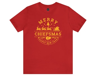 May include: Red t-shirt with a gold graphic that says "Merry Chiefmas & Happy New Year". The graphic features a Christmas tree and Santa Claus in a sleigh.
