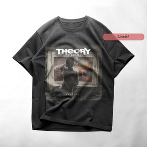 Peut inclure: Un t-shirt noir avec un imprimé graphique du groupe "Theory of a Deadman" et de leur album "Savages".