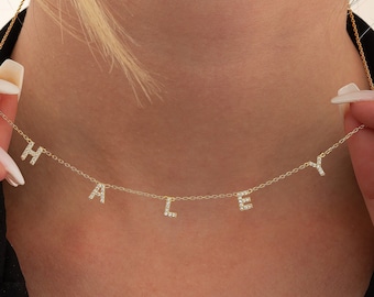 May include: A gold chain necklace with the name "HALLEY" spelled out in small, diamond-encrusted letters.