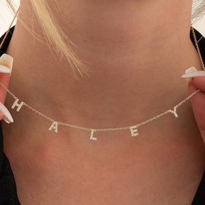 May include: A gold chain necklace with the name "HALLEY" spelled out in small, diamond-encrusted letters.