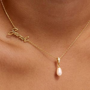 May include: A delicate gold necklace with the name "Sarah" in cursive script. The necklace features a small pendant with a pearl and a diamond accent. The chain is thin and elegant, perfect for everyday wear.