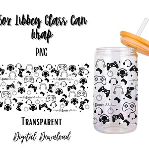 May include: A clear glass can with a bamboo lid and straw, featuring a black and white gamer-themed design. The design includes game controllers, headphones, and the word "Gamer". The can is labeled "16oz Libbey Glass Can Wrap".