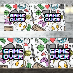 May include: White ceramic mug with a colorful pattern of gaming icons, including controllers, coins, swords, and a headset. The text "GAME OVER" is displayed in a pixelated style with a glitch effect.
