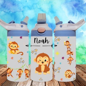 May include: Three blue and white water bottles with a monkey theme. The center bottle has the name "Noah" written on it. Each bottle has a straw and a lid.