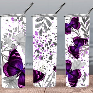 May include: Three stainless steel tumblers with a white background and a purple butterfly design. The tumblers have a grey and purple splatter paint design, grey floral accents, and purple butterflies.
