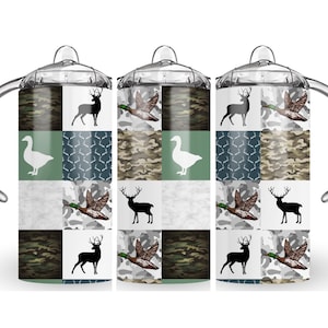 May include: Three stainless steel tumblers with a patchwork design featuring camouflage, geese, ducks, and deer silhouettes. The tumblers have clear lids and a handle.
