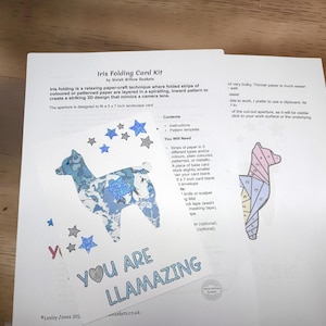 Puede incluir: Un kit de tarjetas Iris Folding de Welsh Willow Baskets con instrucciones impresas y una plantilla. El kit incluye una tarjeta con una silueta de llama de patrón azul, estrellas de purpurina azul y el texto YOU ARE LLAMAZING en letras azules.