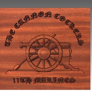 以下が含まれることがあります： 大砲と「The Cannon Cockers 11th Marines」という文字が刻まれた木製の銘板です。