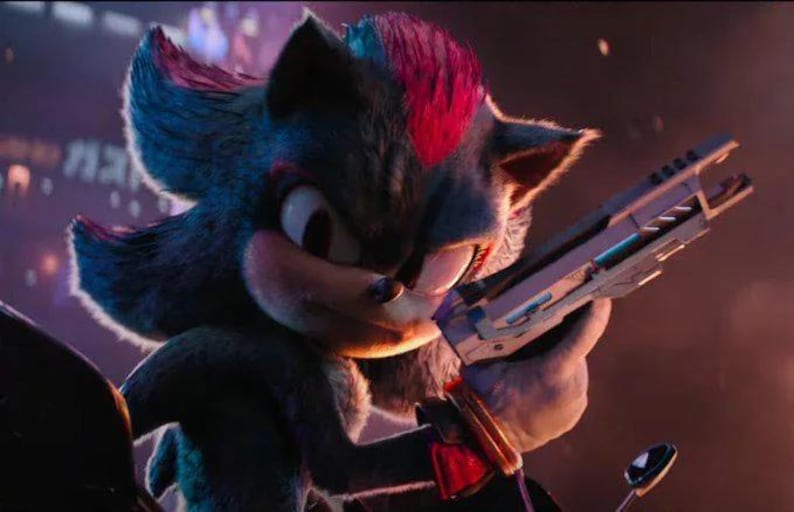 May include: A dark-furred anthropomorphic hedgehog character with red highlights on the head, large eyes, and sharp quills. The character is holding a metallic, futuristic-looking firearm in a forward-facing stance with a focused expression.