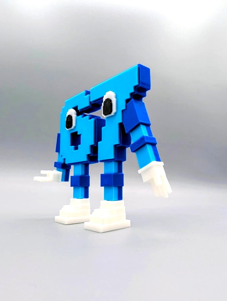 May include: A 3D-printed, pixelated robot figure in shades of blue and white. The robot has a blocky design with a head, body, arms, and legs. The robot's eyes are black, and its hands and feet are white.