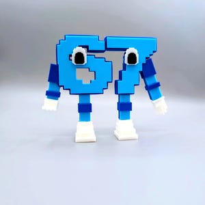 May include: A whimsical, pixelated sculpture of the number 67 in bright blue. The numbers have googly eyes, arms, legs, and white hands and feet, giving them a playful, cartoonish appearance. The design is simple and colorful.