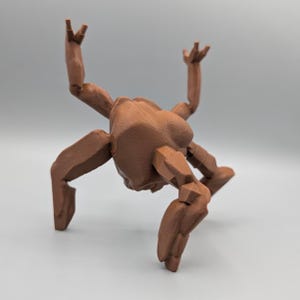 May include: A brown, 3D-printed articulated figure with a stylized, geometric design. The figure has multiple limbs and is posed with its arms raised and legs bent, giving it a dynamic appearance. The figure is made of a solid brown material.