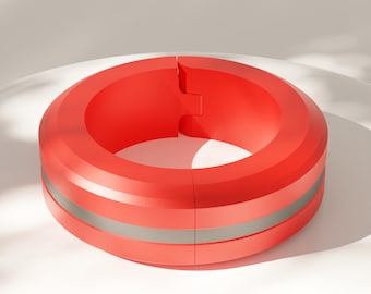 May include: A bright red circular ring featuring a smooth matte finish and a distinct horizontal silver band running around its center. The object has a visible vertical seam where the two ends meet, creating a clean and uniform cylindrical shape.