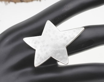 May include: A silver star-shaped ring with a hammered texture.