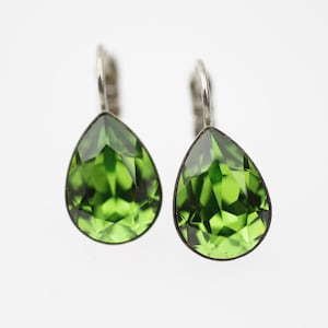 May include: A pair of silver teardrop earrings with green crystal stones.