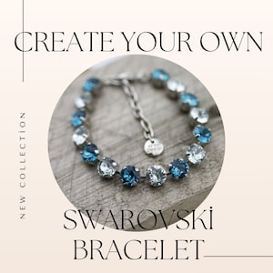 May include: A silver bracelet with blue and clear Swarovski crystals. The bracelet is on a wooden surface. Create Your Own Swarovski Bracelet.
