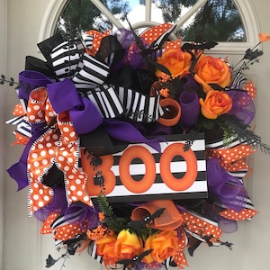 Halloween Door “Boo” wreath with orange roses with bats flying out from them. Big BOO sign will greet your guests. Roses, bats, and creepy!