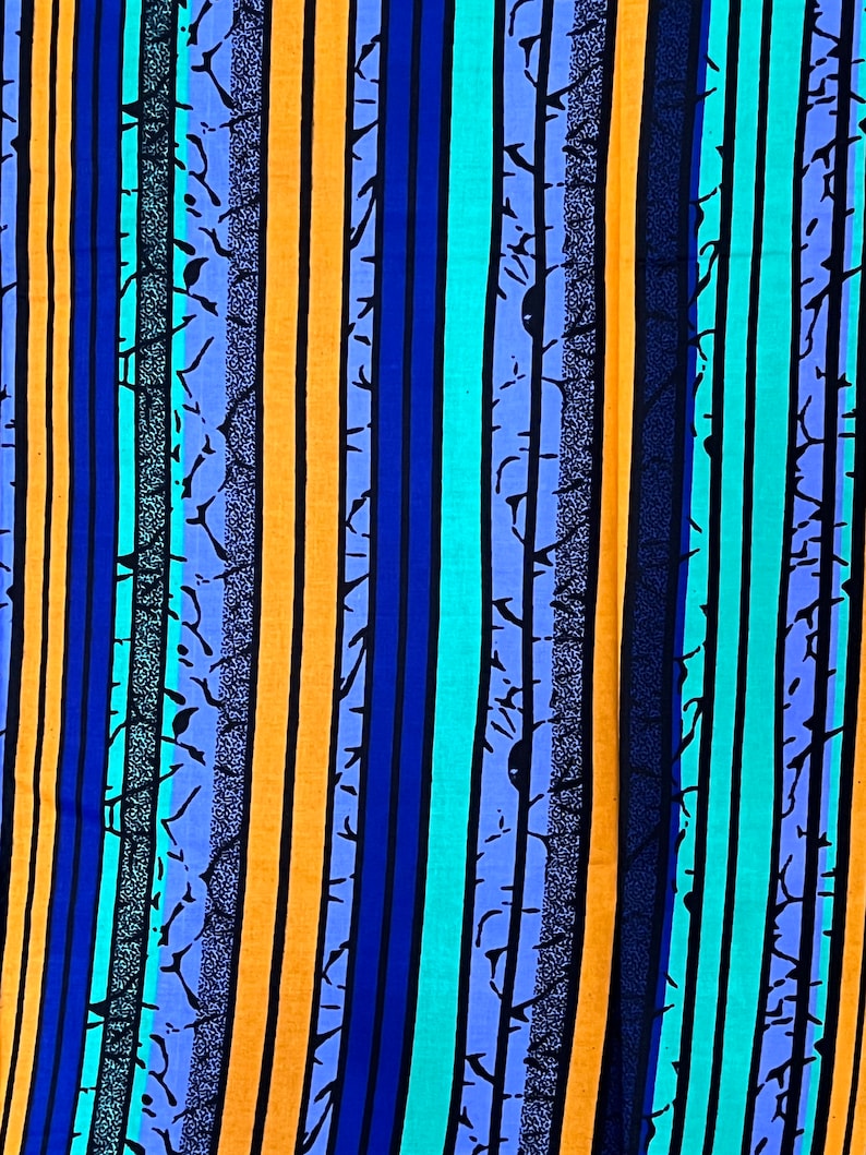 Puede incluir: Una tela colorida con rayas verticales en tonos de azul, naranja y turquesa. Las rayas est&aacute;n adornadas con un dise&ntilde;o negro sutil.