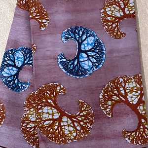 May include: Purple fabric with a repeating pattern of stylised trees with brown and blue branches. The fabric has a subtle watercolour effect and the text "HIBLOCK GABO" is visible at the bottom.