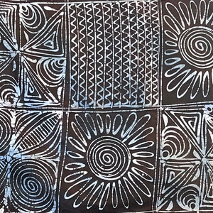 Puede incluir: Una tela batik negra y blanca con un patr&oacute;n geom&eacute;trico. El patr&oacute;n incluye c&iacute;rculos, espirales, tri&aacute;ngulos y l&iacute;neas onduladas.
