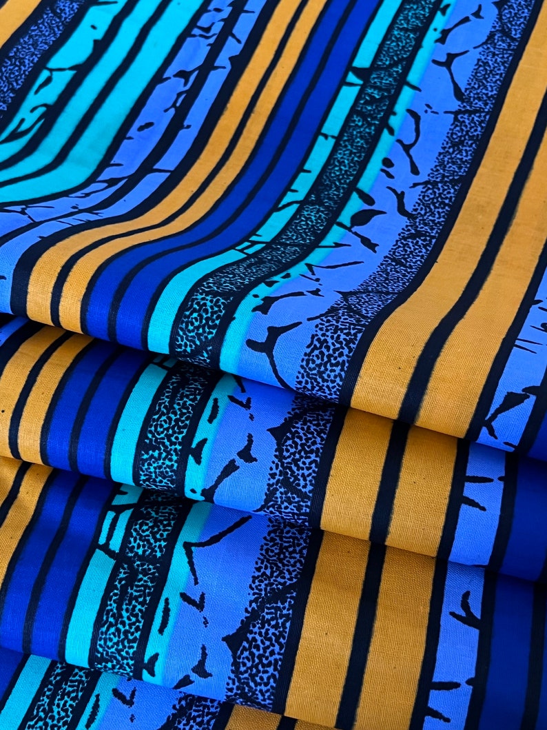 Puede incluir: Tela a rayas con rayas azules y amarillas alternas. Las rayas azules tienen un patr&oacute;n texturizado de puntos negros y blancos y un contorno negro.