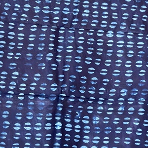 Puede incluir: Tela azul índigo con un patrón repetitivo de semicírculos blancos. La tela tiene una superficie ligeramente texturizada.