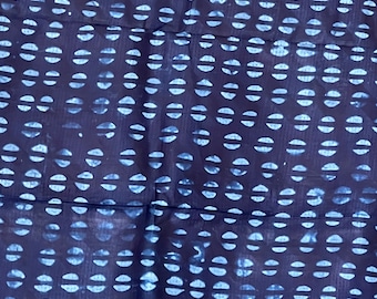 Könnte beinhalten: Indigo blauer Stoff mit einem sich wiederholenden Muster aus weißen Halbkreisen. Der Stoff hat eine leicht strukturierte Oberfläche.