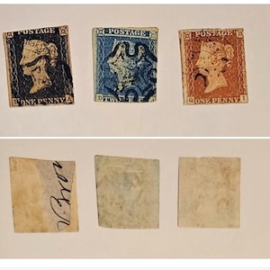 Puede incluir: Tres sellos postales antiguos con el perfil de la reina Victoria. El sello izquierdo es negro con 'POSTAGE' y 'ONE PENNY', el central es azul con 'TWO PENCE' y el derecho es naranja con 'ONE PENNY'. Los reversos muestran la textura del papel.