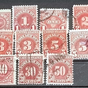 May include: A collection of vintage United States postage due stamps. The stamps feature various denominations from 1/2 cent to 50 cents. The stamps are in red and white with the text "United States Postage Due" printed on each stamp.