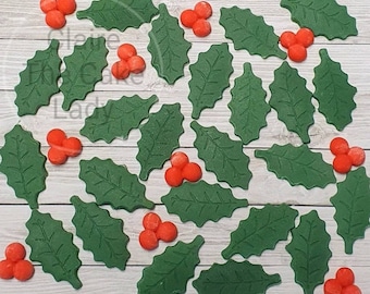 May include: Green holly leaves and red berries, a set of edible decorations for cakes and cupcakes.