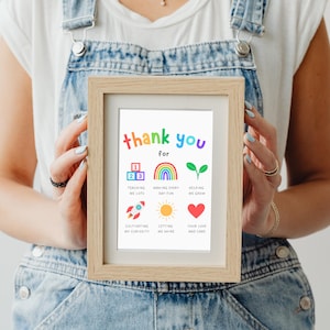 teacher holding a framed thank you gift