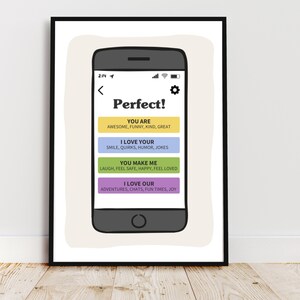 May include: A framed wall art print featuring a dark gray smartphone illustration. The screen displays the text Perfect! followed by four colored rectangular buttons with text: YOU ARE, I LOVE YOUR, YOU MAKE ME, and I LOVE OUR, listing various positive traits.
