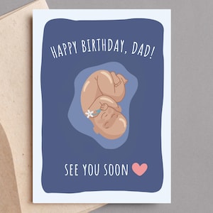 May include: Greeting card with a blue background and the text "HAPPY BIRTHDAY, DAD! SEE YOU SOON". The card features an illustration of a fetus with a flower and a pink heart.