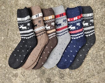 May include: Six pairs of winter socks with a reindeer and snowflake pattern. The socks are in various colors, including black, brown, gray, blue, and dark gray.