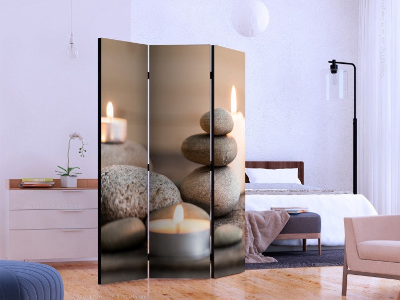 K&ouml;nnte beinhalten: Ein dreiteiliger Raumteiler mit einer ruhigen Spa-Szene. Das Bild zeigt gestapelte Steine, brennende Kerzen und eine weiche, neutrale Farbpalette. Das Design vermittelt ein Gef&uuml;hl von Ruhe und Entspannung, passend f&uuml;r Schlaf- oder Wohnzimmer.