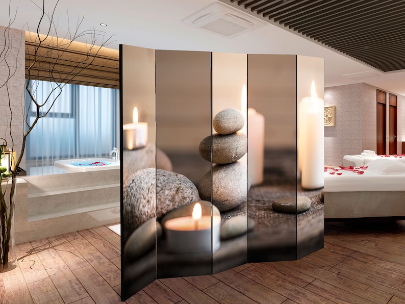 K&ouml;nnte beinhalten: Ein Raumteiler mit einer Spa-Szene mit brennenden Kerzen, gestapelten Steinen und einem verschwommenen Spa-Hintergrund. Der Raumteiler hat einen Holzrahmen und ist in Paneele unterteilt.