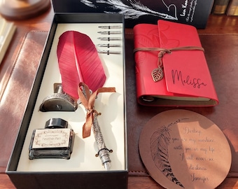 Könnte beinhalten: Ein Kalligraphie-Set mit roter Feder, Tintenfass und Federn, präsentiert in einer schwarzen Box. Enthält ein rotes Notizbuch mit der Aufschrift "Melissa" und einen braunen Untersetzer mit Federdesign und Text.