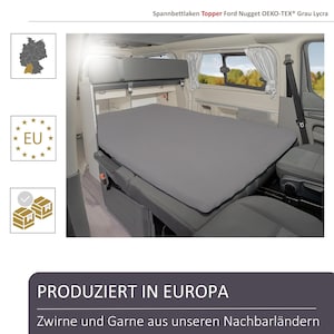 Könnte beinhalten: Ein graues Spannbettlaken, entworfen für einen Ford Nugget, wird in einem Van gezeigt. Das Laken besteht aus OEKO-TEX® Grau Lycra Material. Das Bild enthält auch den Text "PRODUZIERT IN EUROPA".