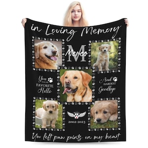 Puede incluir: Una manta conmemorativa negra con huellas de patas y un collage de fotos de un perro golden retriever. La manta tiene el texto "in loving memory", "You were my favorite hello", "And hardest goodbye", "2002-2023", y "You left paw prints on my heart".