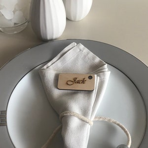 Segni di impostazione del luogo per gli ospiti, tabella dei posti a sedere in legno, posti a sedere rustici al tavolo da matrimonio