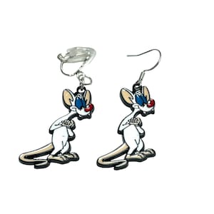 May include: A pair of novelty earrings featuring a cartoon mouse character in a white, black, and red colour scheme. The earrings have a silver-coloured hook and clip-on style. The mouse has blue eyes and a red nose.