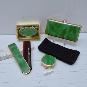 May include: A collection of Stratton vanity accessories featuring a green marbled pattern with gold-tone metal accents. The set includes a rectangular case, a small compact, a comb with a matching handle, and a Lipview case in its original box.