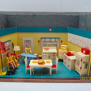 Op de afbeelding: Een vintage poppenhuiskeuken met gele muren, blauwe randen en een blauwe vloer. De scène bevat miniatuurmeubels, apparaten en beeldjes. Een rode vogelkooi, een gedekte tafel en een koelkast zijn zichtbaar.