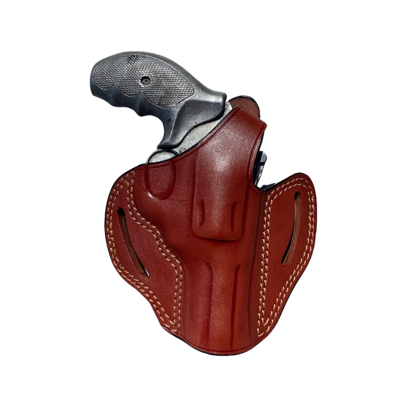 K&ouml;nnte beinhalten: Ein braunes Lederholster f&uuml;r eine kleine Pistole. Das Holster hat ein gen&auml;htes Design und eine Klappe, die die Waffe bedeckt.